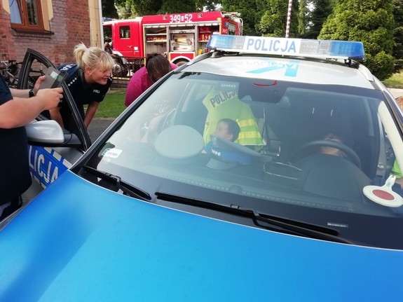 policyjny radiowóz, do którego wsiadają dzieci podczas pikniku w Polance