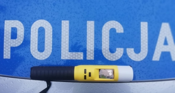 urządzenie do badania stanu trzeźwości - Alcoblow na tle napisu Policja