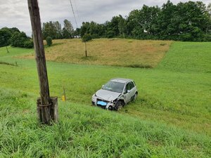 . Zdjęcie kolorowe przedstawia miejsce zdarzenia drogowego w miejscowości Olszany. Na zdjęciu widoczny pojazd m-ki fiat koloru srebrnego z uszkodzonym lewym przednim narożem pojazdu