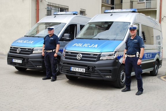 Zdjęcie radiowozów na dziedzińcu KMP w Rzeszowie obok pojazdów stoją policjanci ruchu drogowego.