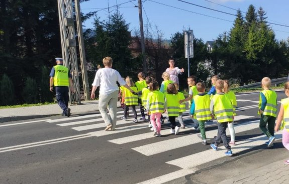 dzieci przechodzące przez przejście dla pieszych z policjantem