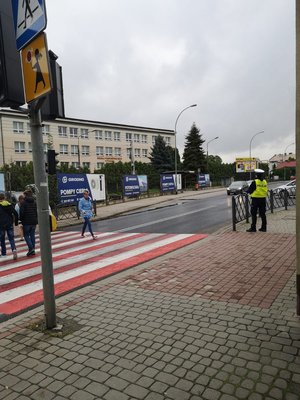 Zdjęcie kolorowe zrobione na ul. W.Pola w Przemyślu obok szkoły Podstawowej nr 15. Na zdjęciu widoczne jest przejście dla pieszych a obok przejścia stoi umundurowana policjantka. Zdjęcie z akcji Bezpieczna droga do szkoły