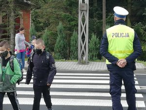 policjant i dzieci przechodzące przez przejście dla pieszych