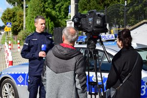 policjant rozmawiający z dziennikarzami
