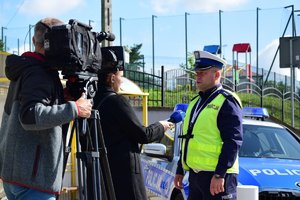 policjant rozmawiający z dziennikarzami