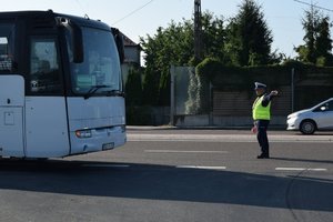 policjant pokazuje kierowcy autobusu kierunek zjazdu