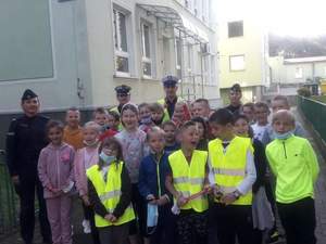 policjanci wraz z dziećmi w kamizelkach odblaskowych