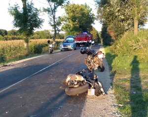 Miejsce wypadku drogowego w Pantalowicach. Na zdjęciu widoczny jest motocykl biorący udział w wypadku, obok dwa inne, w tle policyjny radiowóz i straży pożarnej.