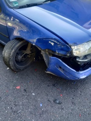 Zdjęcie kolorowe wykonane w porze dziennej  w miejscowości Przemyśl na ul. Krakowskiej.  Na zdjęciu widoczny jest samochód osobowy m-ki VW Bora koloru niebieskiego z widocznymi uszkodzeniami po kolizyjnymi.