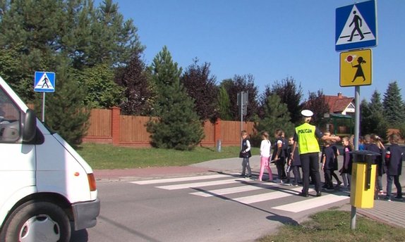 Policjantka Wydziału Ruchu Drogowego przeprowadzająca dzieci przez przejście dla pieszych