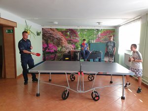 na zdjęciu policjanci grający w tenisa stołowego z podopiecznymi