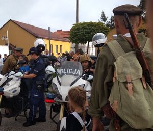 Na policyjnym motocyklu znajduje się dziecko, obok jest policjantka