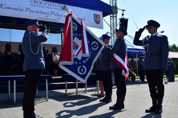 Komendant Powiatowy Policji w Ropczycach salutujący przy sztandarze.