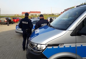 policjanci kontrolują zagranicznych grzybiarzy, w tle samochody obcokrajowców i ich pasażerowie