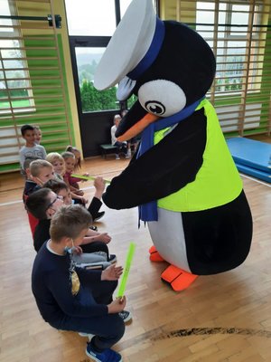 Maskotka Pingwin przekazuje dzieciom odblaski