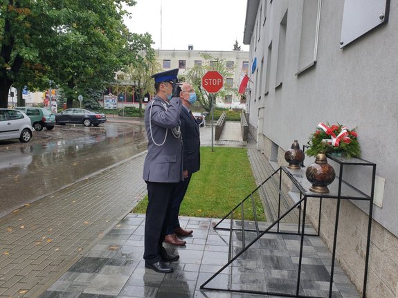 komendant Policji wraz z dyrektorem mieleckiego muzeum składają kwiaty pod tablicą zamieszczoną na froncie budynku KPP Mielec