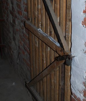 Zdjęcie kolorowe wykonane w porze dziennej -przedstawia drzwi do piwnicy jednego z bloków w Przemyślu . Miejsce kradzieży z włamaniem