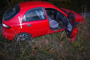 Zdjęcie kolorowe wykonane w porze nocnej-przedstawia miejsce zdarzenia drogowego w miejscowości Zalesie oraz pojazd m-ki daewoo lanos w kolorze czerwonym po kolizji z rowerem