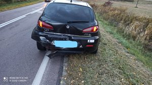 Zdjęcie kolorowe  wykonane w prze dziennej przedstawia pojazd po kolizji drogowej m-ki  alfa romeo w kolorze granatowym