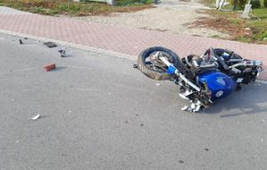 Uszkodzony w wyniku wypadku motocykl leży na jezdni.