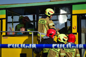 Zbliżenie na autobus - strażacy w środku i na zewnątrz udzielają pomocy poszkodowanym