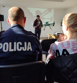 szkolenie z udziałem operatora drona, na pierwszym planie policjant w mundurze uczestniczący w szkoleniu