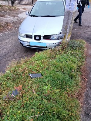 Zdjęcie kolorowe wykonane porze dziennej przedstawia pojazd marki seat koloru srebrnego który brał udział w kolizji . Pojazd ma uszkodzenia z z przodu z  lewej strony od kierowcy