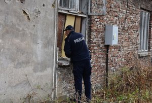Policjant sprawdza niezamieszkały budynek