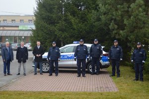 na fotografii policjanci, nowy radiowóz oraz pracownicy gminy Wadowice Górne na tle posterunku Policji