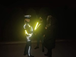 na fotografii policjantka rozmawiająca z pieszymi, w ręce trzyma opaski odblaskowe