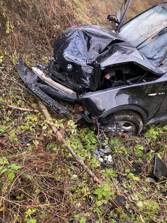 Zdjęcie kolorowe wykonane w porze dziennej przedstawia miejsce zdarzenia drogowego w miejscowości Bircza. Na zdjęciu widoczny samochód m-ki BMW koloru granatowego zaparkowany w rowie , posiada rozpity przód samochodu.