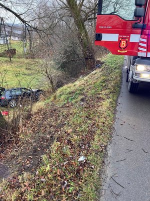 Zdjęcie kolorowe wykonane w porze dziennej przedstawia miejsce zdarzenia drogowego w miejscowości Bircza. Na zdjęciu widoczny samochód m-ki BMW koloru granatowego zaparkowany w rowie . Po prawej stronie zdjęcia widoczny jest częściowo wóz straży pożarnej w kolorze czerwonym