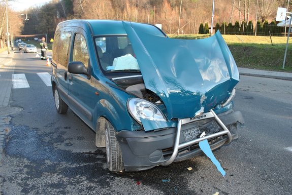 Zdjęcie kolorowe wykonane w porze dziennej przedstawia miejsce zdarzenia drogowego w miejscowości Przemyśl ul. Sanocka . Na zdjęciu widoczny jest pojazd  marki renault kango koloru granatowego z uszkodzonym przodem pojazdu.