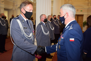 Komendant Wojewódzki Policji w Rzeszowie insp. Dariusz Matusiak (po prawej) wręcza odznaczenie policjantowi.