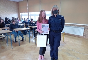 Na zdjęciu policjantka przekazująca dyplom i upominek uczestniczce konkursu &quot;Bezpieczne wakacje 2012&quot;