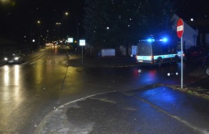 policyjny radiowóz z włączonymi światłami błyskowymi koloru niebieskiego na miejscu potrącenia pieszej
