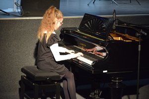 dziewczynka podczas koncertu grająca na fortepianie