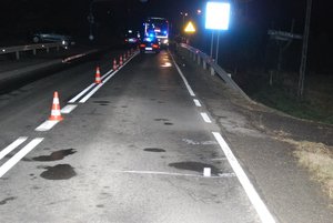 Zdjęcie kolorowe wykonane w porze nocnej, przedstawia miejsce zdarzenia drogowego (potrącenie pieszego) w miejscowości Stara Bircza. Na zdjęciu widoczna jest jezdnia na której ustawione są tz. pachołki, oraz trzy pojazdy
