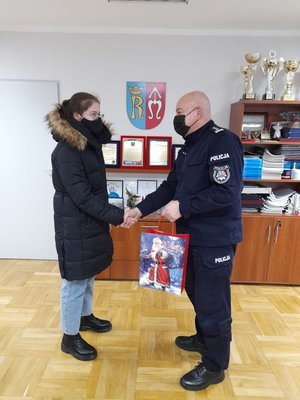 Komendant Powiatowy Policji w Ropczycach wręczający dyplom i nagrody laureatce konkursu