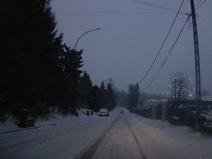 Droga dojazdowa do centrum Łańcuta. Cała jezdnia pokryta jest śniegiem. Po prawej stronie zasypany śniegiem chodnik.