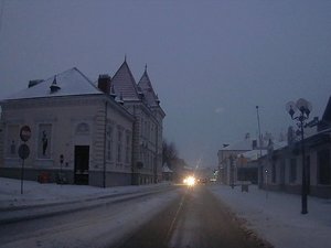 Centrum miasta. Na jezdni zalega błoto pośniegowe. Chodniki przysypane śniegiem.