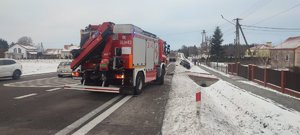 Zdjęcie kolorowe wykonane w porze dziennej -przedstawia drogę krajową nr 28 w miejscowości Orły, na której doszło do zdarzenia drogowego. Po prawej stronie zdjęcia widoczne sa budynki mieszkalne oraz droga na której w rowie widoczny jest pojazd m-ki ford w czarnym kolorze a za nim zaparkowany pojazd Straży pożarnej