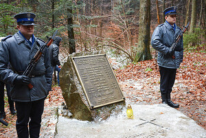 zdjęcie z archiwum KWP pomnik upamiętniający policjantów, którzy zginęli w Cisnej, przy nim umundurowani funkcjonariusze
