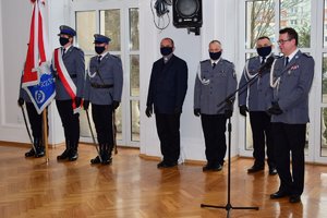 Po prawej przy mikrofonie inspektor Zbigniew Sowa, w tle policjanci i poczet sztandarowy.