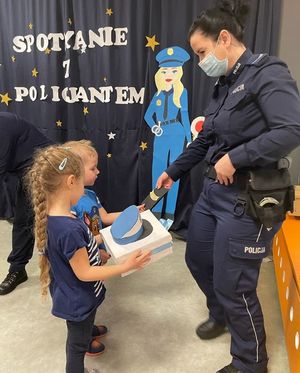 Dziewczynka przekazuje policjantce prezent