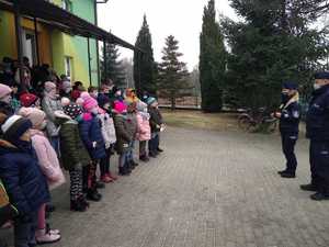 policjanci podczas rozmowy z dziećmi przed budynkiem szkoły