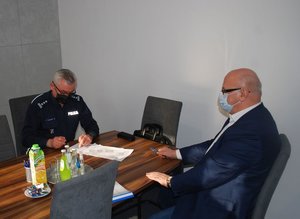 Od lewej siedzący przy stole Komendant Powiatowy Policji w Ropczycach insp. Dariusz Matusiak, po prawej Wójt Gminy Wielopole Skrzyńskie Marek Tęczar
