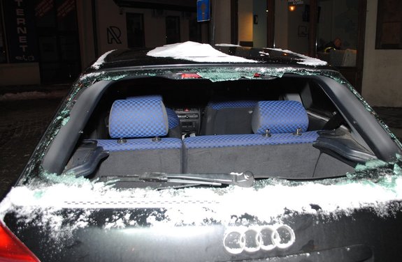 Zdjęcie kolorowe wykonane w porze nocnej –przedstawia tył samochodu m-ki audi koloru granatowego z rozbita szybą tylną.