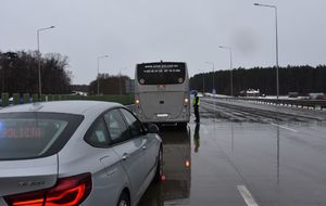 Policjant kontroluje autobus na autostradzie