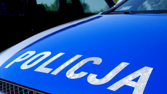 Zdjęcie kolorowe przedstawia pokrywę silnika radiowozu policyjnego która jest w kolorze niebieskim, na pokrywie widnieje napis &quot;POLICJA&quot; w białym kolorze